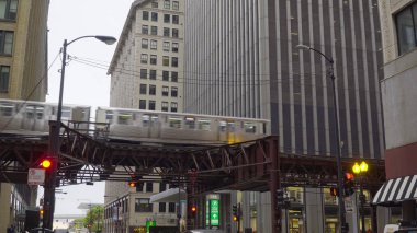 Chicago, Usa - 2019 dolaylarında, yoğun şehir merkezinden sabah trafiği sırasında ofis binalarının arasından geçen döngü treni, iş yerine giden yolcularla işe gidip geliyor.