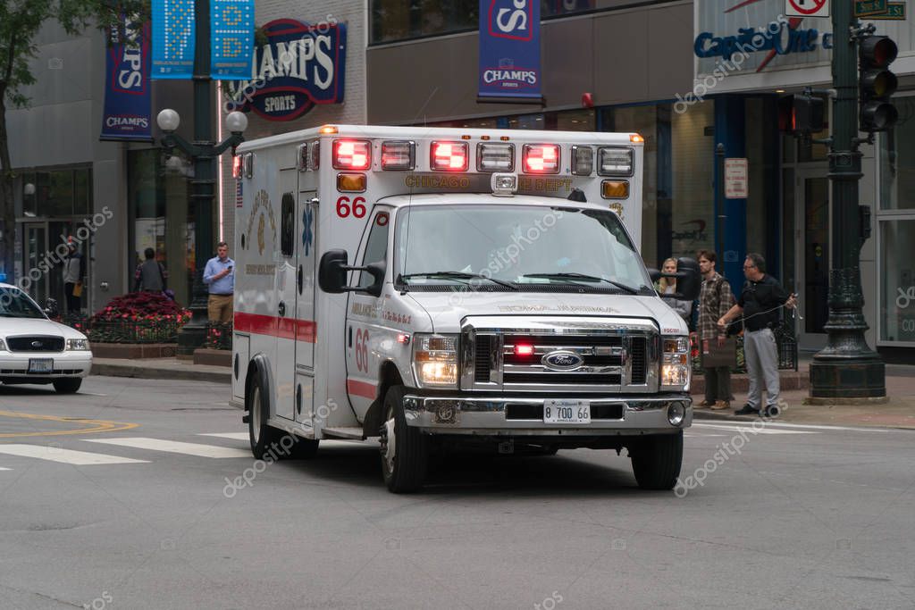 Chicago, USA - Circa 2019: Chicago PD ambulance rushing through downtown intersection towards emergency medical scene to help people in need of doctor at hospital