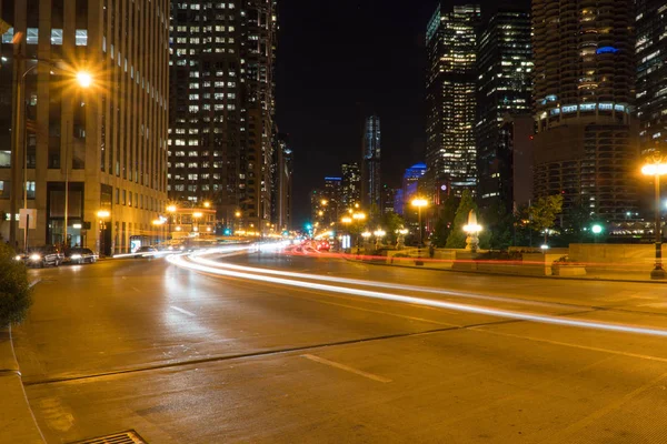 大都市交差点 背景にスカイラインを介して高速道路を走行車のライトトレイルと一般的な忙しいダウンタウンの都市の通りの夜の時間の長い露出 — ストック写真