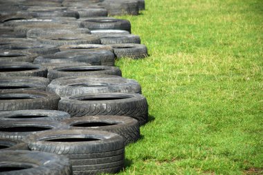 Yeşil çimlerin üzerinde duran araba lastikleri
