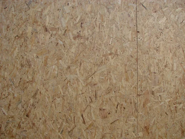 close up pressed wooden panel background, seamless texture of oriented strand board - OSB wood
