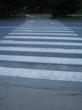 İnsanlar caddeden karşıya geçerken güvenlikleri için yaya geçidinde yürüyorlar..