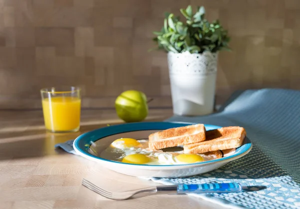 Spiegeleier auf dekorativem Teller mit Toastbrot, grünem Apfel und Orangensaft — Stockfoto