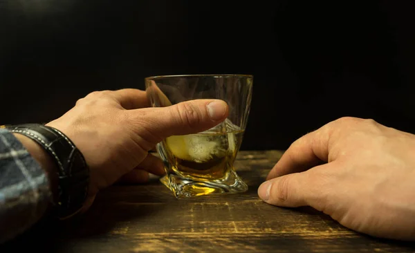 Mano Dell Uomo Bicchiere Whisky Con Cubetti Ghiaccio Tavolo Legno — Foto Stock