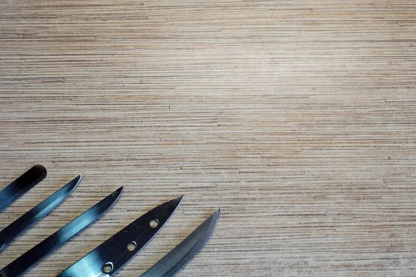 Sharp knives. Metal objects. The wooden table. The view from the top. Background. A fragment of the object. Design element