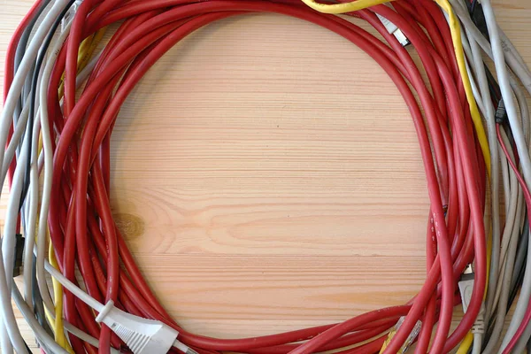 Rolled into a ring cable. Different colors of wires. Round shape. Wooden table. The view from the top. Electrical wire. Design element.