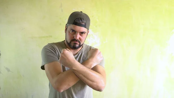 A man by the wall shows his muscles. Athlete in the gym. Healthy lifestyle.