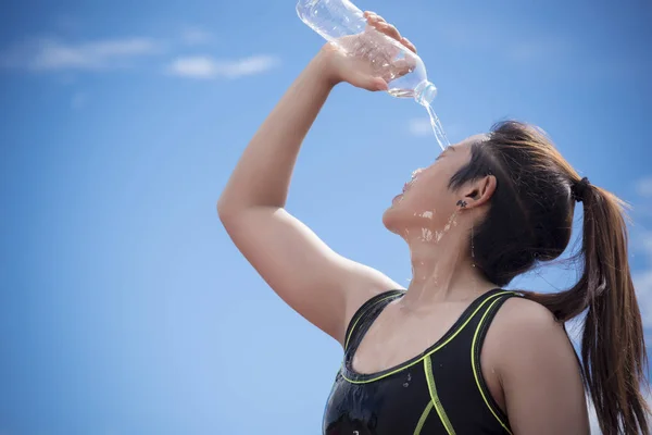 Sport girl pouring water on her face when rest or take a break t — Stock Photo, Image