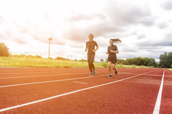 Two runners jogging on the race track, Sport and Social activity