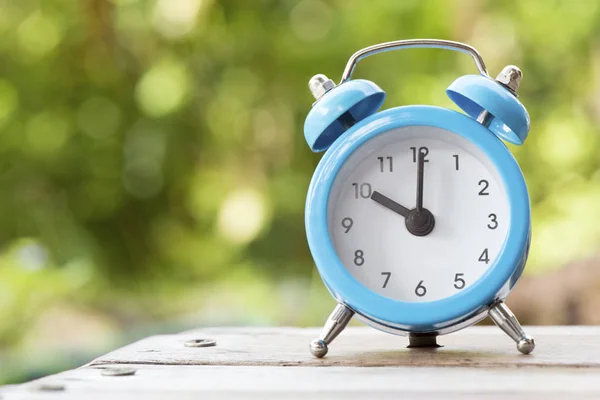 Reloj despertador azul y blanco en la mesa de madera, hora y horario — Foto de Stock