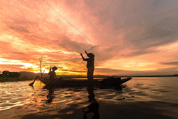 Silhouette Fischer Angeln mit dem Netz auf dem Boot am Morgen in Thailand, Natur-und Kulturkonzept — Stockfoto