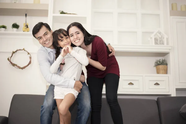 Happy family in happy mood with hug, smiling togetherm Mom, Dad and daughter acting happiness concept — стоковое фото