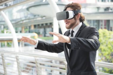 Businessman wearing virtual reality goggle glasses and enjoying  clipart