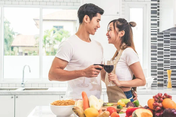 Aziatische liefhebbers of paren het drinken van wijn op kamer van de keuken thuis. Liefde en geluk concept zoet wittebroodsweken en het thema van de dag van Valentijn — Stockfoto