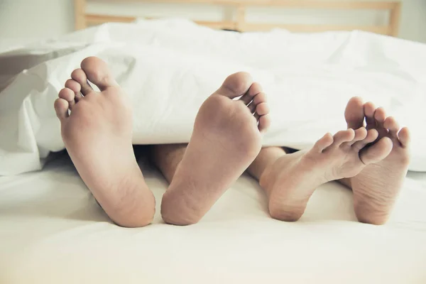 A piedi nudi di amanti sotto coperta in camera da letto. Vacanza e Felicità del sessuale. Tema di San Valentino. Tema della mattina di festa — Foto Stock