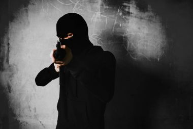 Onun savaş silah silah ile terk edilmiş binada arka planda ile çekim bir terörist. Ceza ve tehlikeli yasadışı insanlar kavramı. Terör ve savaş Tema. Koyu tonu ve yüksek karşıtlık kullan