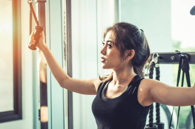 Asyalı genç kadın fitness spor çapraz, Elastik ipi egzersizleri yapıyor. Eğitim ve kas gücü. Güzellik ve sağlıklı bir kavram. Spor donatımı ve spor kulübü Merkezi Tema. 
