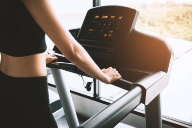 Asya spor kadın yürüyen ya da egzersiz jimnastik koşu bandı donanımları üzerinde çalışan. Spor ve güzellik kavramı. Egzersiz ve vücut geliştirme Tema. Kardiyo ve diyet Tema