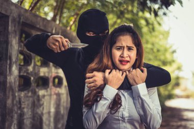 Kidnapper or Robber force knifepoint woman hostage to take off her clothes or steal her money at outdoors road. Raping sexual and Criminal theme. Social issues and problem concept clipart