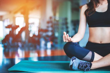 Kadının Yoga mat fitness salonunda yapması. Spor ve egzersiz kavramı. Meditasyon ve Fitness Tema. Seçici odak üstünde el