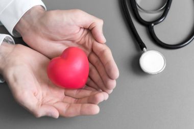 Üstten bakış doğum Doktor iki eller tarafından hastaya mini kalp stetoskop tıbbi aletleri ile ver, nimet için olsun iyi ve sağlık kavramı