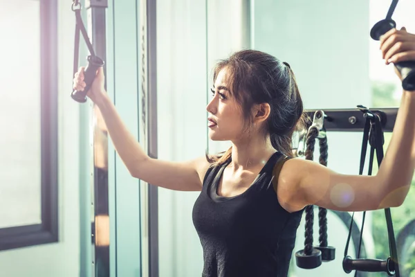 Mujer joven asiática haciendo ejercicios de cuerda elástica en el gimnasio cross fitness. Entrenamiento de fuerza y musculatura Belleza y concepto saludable. Equipo deportivo y centro temático Sport club . —  Fotos de Stock