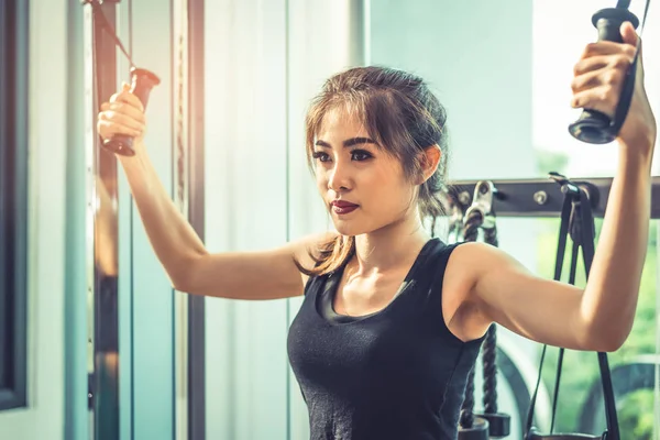 Mujer joven asiática haciendo ejercicios de cuerda elástica en el gimnasio cross fitness. Entrenamiento de fuerza y musculatura. Belleza y concepto saludable. Equipo deportivo y centro temático Sport club . —  Fotos de Stock