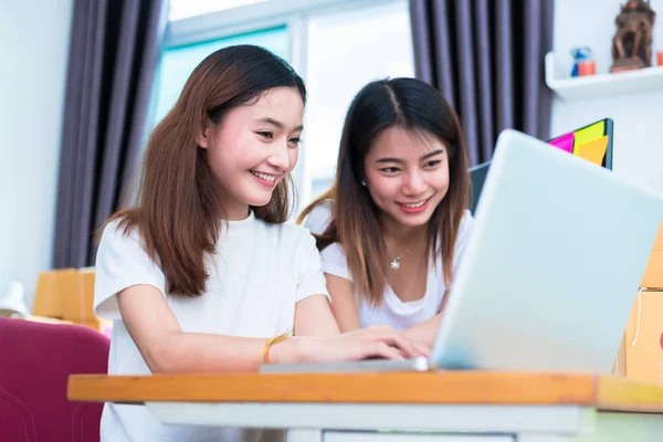 Twee jonge freelancer Aziatisch meisje zakenvrouwen privé bezig thuis kantoor met een laptop of computer met Laptop Bureau. verpakking levering online winkelen en marketing service aan klanten — Stockfoto