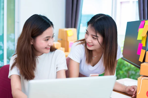 Två asiatiska vänskap kvinnor söker tillsammans när använda laptop för on-line shopping och marknadsföring eller sälja produkt i office. Företag leverans och service — Stockfoto