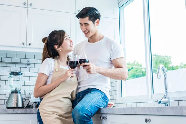 Aziatische liefhebbers of paren het drinken van wijn op kamer van de keuken thuis. Liefde en geluk concept zoet wittebroodsweken en het thema van de dag van Valentijn — Stockfoto