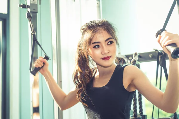 Азиатская девушка делает упражнения на эластичной веревке в тренажерном зале. Силовая тренировка и мускулатура. Красота и здоровая концепция. Спортивное оборудование и тематика спортивного клуба . — стоковое фото