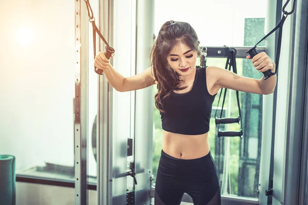 Mujer joven asiática haciendo ejercicios de cuerda elástica en el gimnasio cross fitness. Entrenamiento de fuerza y musculatura. Belleza y concepto saludable. Equipo deportivo y centro temático Sport club . —  Fotos de Stock