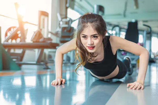 Mujer asiática chica de fitness hacer flexiones en el gimnasio de fitness. Salud y concepto saludable. Formación y Cuerpo construir el tema. Concepto de fuerza y belleza —  Fotos de Stock