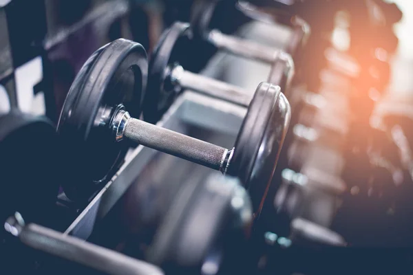 Conjunto de mancuerna de acero negro. Primer plano de mancuernas en el estante en el gimnasio deportivo. Ejercicio de entrenamiento y fitness concepto de gimnasio. Concepto de bienestar y salud. Equipo deportivo y tema de la herramienta . — Foto de Stock