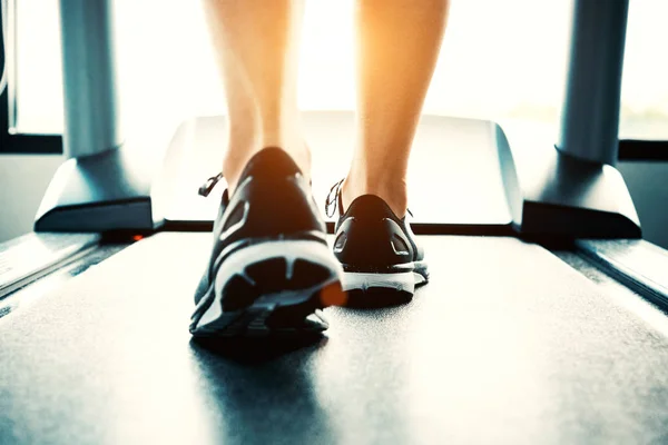 Detailní záběr lidí, kteří cvičení na běžeckém pásu. Detail nohy žena chůze robota v sportovního klubu. Fitness a tělo vybudovat koncept. Cvičení a koncepce školení sílu. Sportovní klub téma. — Stock fotografie