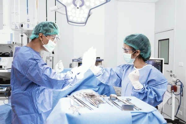 Los médicos y la enfermera hacen hola cinco después de tener éxito de la cirugía en la sala de operaciones. Concepto sanitario y hospitalario — Foto de Stock