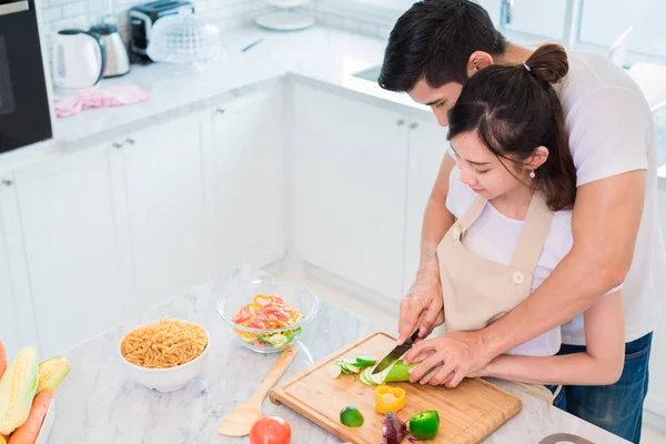 Vista superior de los amantes asiáticos o parejas que preparan el desayuno por la mañana en la sala de cocina. Hombre enseñando a la mujer a cortar verduras y arroz. Concepto de relación y familia. Tema Luna de miel y festivos — Foto de Stock