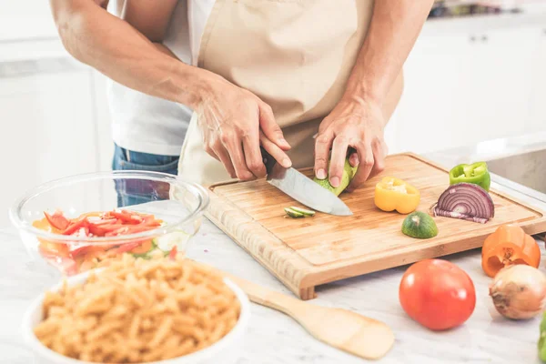 Händerna på par eller älskare matlagning och skivning grönsaker med kniv tillsammans. Man undervisning kvinna att laga. Lycka i holiday och smekmånad koncept — Stockfoto