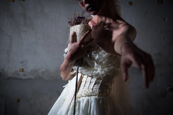 Mariée Zombie en robe de mariée avec des fleurs séchées pointant et veulent que vous restiez avec elle dans la maison abandonnée, thème d'Halloween, concept fantôme et homme mort, concept brisé et négligé coeur, ton sombre — Photo