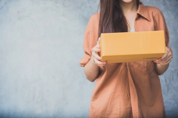 Wanita memegang kotak paket untuk diantar kepada pelanggan melalui layanan logistik. konsep kecil gudang distribusi UKM. pemilik kecil home office dan tema produk pemasaran online — Stok Foto
