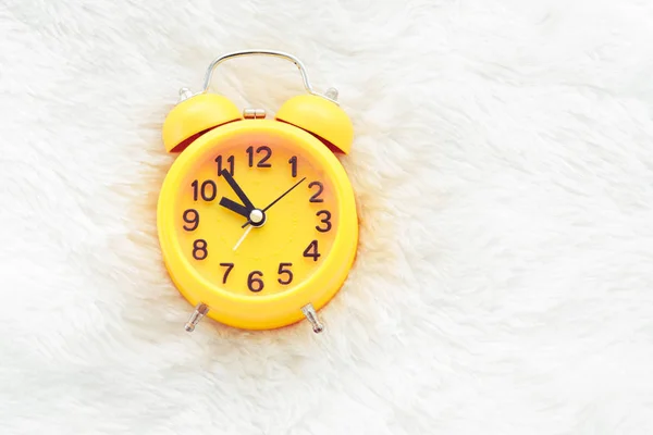 Reloj despertador amarillo en lana blanca. Concepto de tiempo tardío y perezoso. Mañana en el tema de vacaciones. Alrededor de 10 O Reloj — Foto de Stock