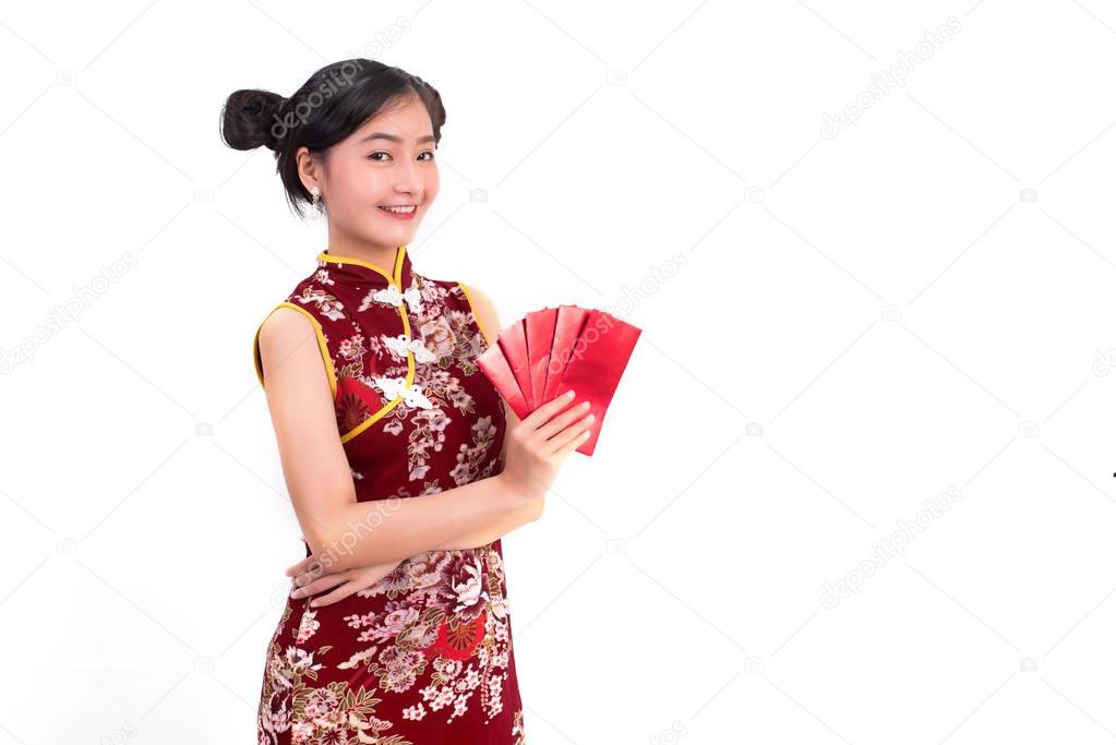 Young Asian beauty woman wearing cheongsam and holding packet of moneys gesture in Chinese new year festival event on isolated white background. Holiday and Lifestyle concept. Qipao dress wearing