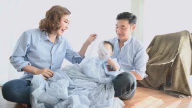 Ebeveynler evdeki yatak odasında yarı Japon bir oğlanla oynuyorlar. Mutlu aile ve bebek konsepti. Çok ırklı, melez insanlar. Ebeveynliği ve çocuğu takdir et. Beraberlik ve mutluluk ilişkisi