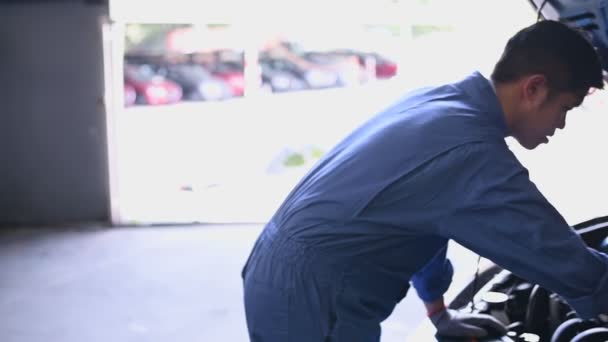 Молодой Азиатский Автомеханик Осматривает Двигатель Автомобильном Капоте Авторемонтной Мастерской Ремонтник — стоковое видео