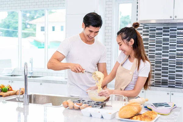 Feliz asiática parejas cocinar y hornear pastel juntos en cocina — Foto de Stock