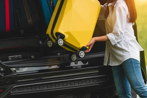 Asiatin hebt gelben Koffer während der Fahrt in Geländewagen — Stockfoto