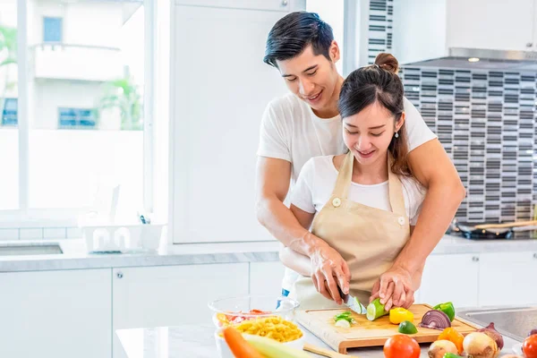 Asiáticos parejas cocinar y rebanar verduras en la cocina juntos . — Foto de Stock