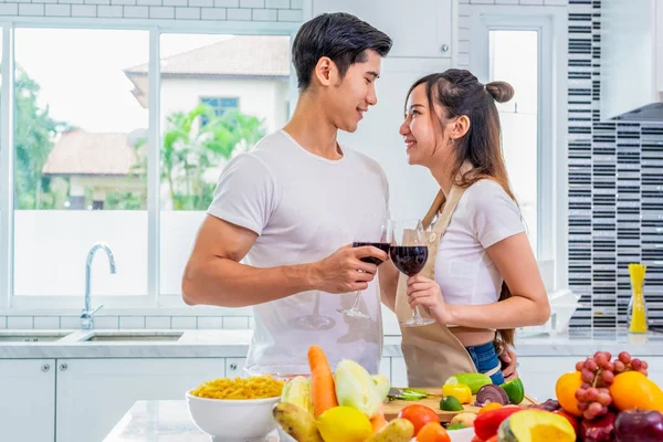 Feliz asiático joven casado pareja bebiendo vino y buscando cada uno — Foto de Stock