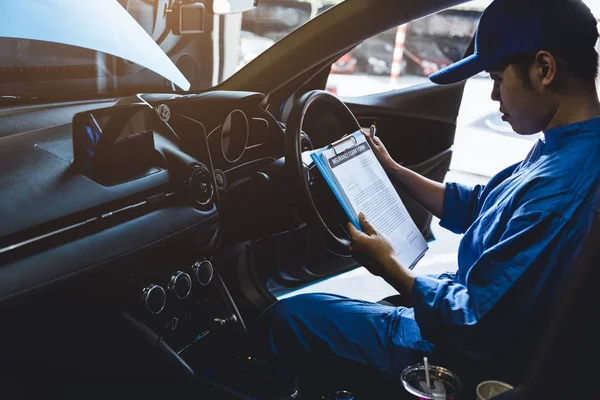 Mechaniker hält Klemmbrett und überprüft im Auto die Wartung — Stockfoto