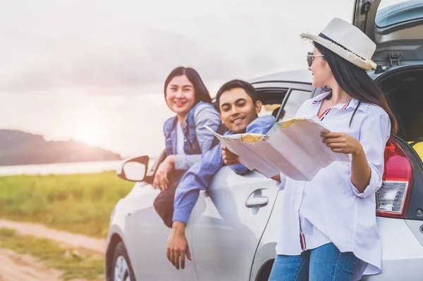 Glücklich asiatische Frau und ihre Freunde stehen mit dem Auto auf Küstenroa — Stockfoto